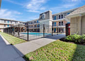 Thumbnail 3 of 8 - A black fence surrounds a pool in a residential area.