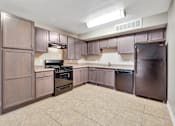 Thumbnail 7 of 8 - A kitchen with brown cabinets and appliances.