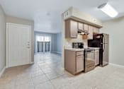 Thumbnail 6 of 8 - A kitchen with a refrigerator, oven, and microwave.