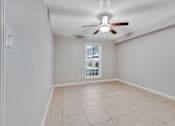 Thumbnail 8 of 8 - A room with a ceiling fan and tiled flooring.