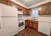 Thumbnail 27 of 33 - a kitchen with white appliances and wooden cabinets
