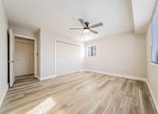 Thumbnail 14 of 25 - A room with a ceiling fan and wooden flooring.