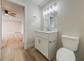 Thumbnail 17 of 25 - A white bathroom with a toilet, sink, and mirror.