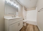 Thumbnail 16 of 25 - A white bathroom with a toilet, sink, and mirror.