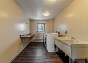 Thumbnail 25 of 25 - A laundry room with a washer and dryer and a sink.