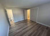 Thumbnail 28 of 32 - A room with wooden flooring and white walls.