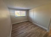 Thumbnail 29 of 32 - A room with a window and a wooden floor.