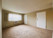 Thumbnail 8 of 27 - an empty living room with a white door and a window