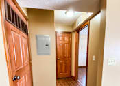 Thumbnail 5 of 18 - an empty hallway with a wooden door and a door to a bedroom and a hallway