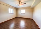 Thumbnail 7 of 18 - an empty bedroom with wooden floors and a ceiling fan