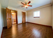 Thumbnail 8 of 18 - an empty bedroom with wooden floors and a ceiling fan