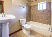 Thumbnail 6 of 18 - a bathroom with a toilet and a sink and a bath tub