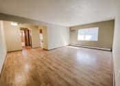 Thumbnail 9 of 18 - an empty living room with wood floors and a window