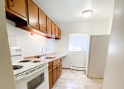 Thumbnail 10 of 18 - an empty kitchen with white appliances and wooden cabinets