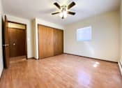 Thumbnail 14 of 18 - an empty bedroom with wooden floors and a ceiling fan