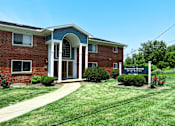 Thumbnail 1 of 18 - the front of a brick building with a sign in front