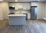 Thumbnail 15 of 22 - A kitchen with a white island and a refrigerator.