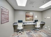 Thumbnail 16 of 30 - A room with a poster on the wall and two chairs in front of a desk at Independence Place Apartments, Parma Heights