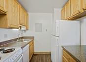Thumbnail 18 of 30 - A kitchen with white appliances and wooden cabinets at Independence Place Apartments, Ohio 44130