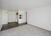 Thumbnail 23 of 30 - A large empty room with a carpeted floor and white walls at Independence Place Apartments, Parma Heights, Ohio