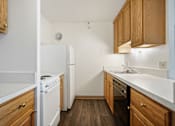Thumbnail 19 of 30 - A kitchen with wooden cabinets and white appliances at Independence Place Apartments, Ohio