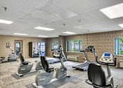Thumbnail 14 of 30 - A gym with treadmills and elliptical machines at Independence Place Apartments, Parma Heights, OH 44130