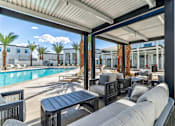Thumbnail 5 of 17 - A patio area with a pool and palm trees.