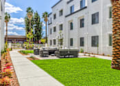 Thumbnail 15 of 17 - A white building with a palm tree in front.