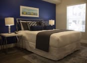 Thumbnail 14 of 75 - a bedroom with a blue accent wall and a white bed with a black and white comfort at The Crossings at Redlands, California, 92374