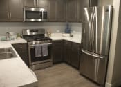 Thumbnail 40 of 75 - a kitchen with gray cabinets and stainless steel appliances at The Crossings at Redlands, California, 92374