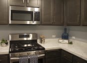 Thumbnail 42 of 75 - a kitchen with a stove and a microwave at The Crossings at Redlands, California, 92374