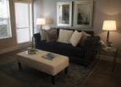 Thumbnail 25 of 75 - a living room with a black couch and a white ottoman at The Crossings at Redlands, California
