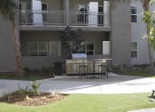 Thumbnail 5 of 75 - a patio with a grill and table in front of an apartment building at The Crossings at Redlands, Redlands, CA, 92374