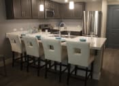 Thumbnail 55 of 75 - a kitchen with a large island and a stainless steel refrigerator  The Crossings at Redlands, Redlands, 92374