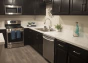 Thumbnail 57 of 75 - a kitchen with black cabinets and white countertops at The Crossings at Redlands, California, 92374