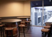Thumbnail 29 of 75 - a bar area with wooden tables and stools and a large window with a view of a at The Crossings at Redlands, Redlands, 92374