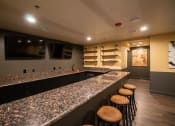 Thumbnail 18 of 75 - a basement bar with stools and a television at The Crossings at Redlands, California, 92374