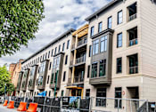 Thumbnail 16 of 16 - A row of new apartment buildings are under construction.