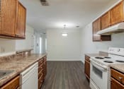 Thumbnail 3 of 10 - A kitchen with white appliances and wooden cabinets at Carriage Hills, Lumberton, NC 28358