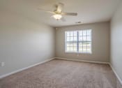 Thumbnail 6 of 10 - A room with a ceiling fan and carpeted floor at Carriage Hills, Lumberton, NC 28358
