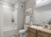 Thumbnail 8 of 23 - A white bathroom with a toilet, sink, and shower.