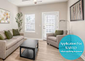 Thumbnail 2 of 23 - A living room with a couch, a coffee table, and a painting on the wall.