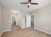 Thumbnail 7 of 23 - A room with a ceiling fan and wooden floors.