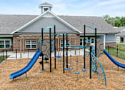Thumbnail 17 of 23 - A playground with a blue slide and a green climbing frame.