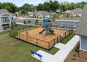 Thumbnail 18 of 23 - A playground with a blue slide and a brown sandbox.