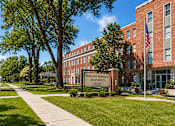 Thumbnail 15 of 17 - A brick building with a sign that says Highland Memorial Apartments.