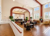 Thumbnail 6 of 9 - A large room with tables and chairs and a long arched window.