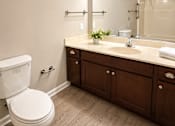 Thumbnail 6 of 17 - A white toilet sits next to a sink in a bathroom.