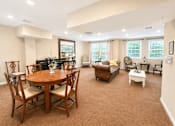 Thumbnail 10 of 17 - A living room with a brown carpet and wooden furniture.