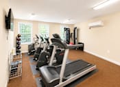 Thumbnail 17 of 17 - A home gym with treadmills, elliptical machines, and a television.